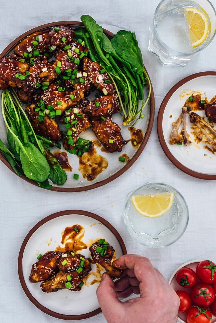 Ofengebackene Sticky Chicken Wings mit Sesam und Kräutern (Aufsicht)