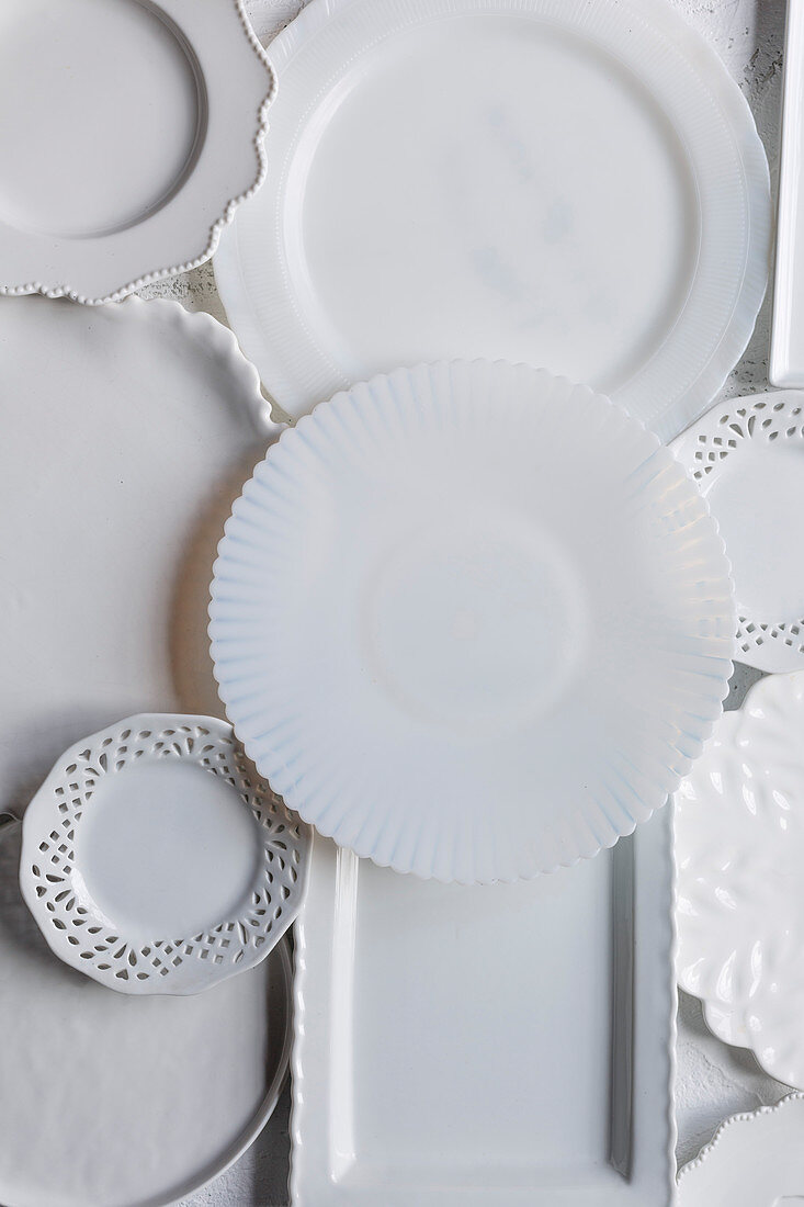 Verschiedene weiße Teller und Platten aus Porzellan