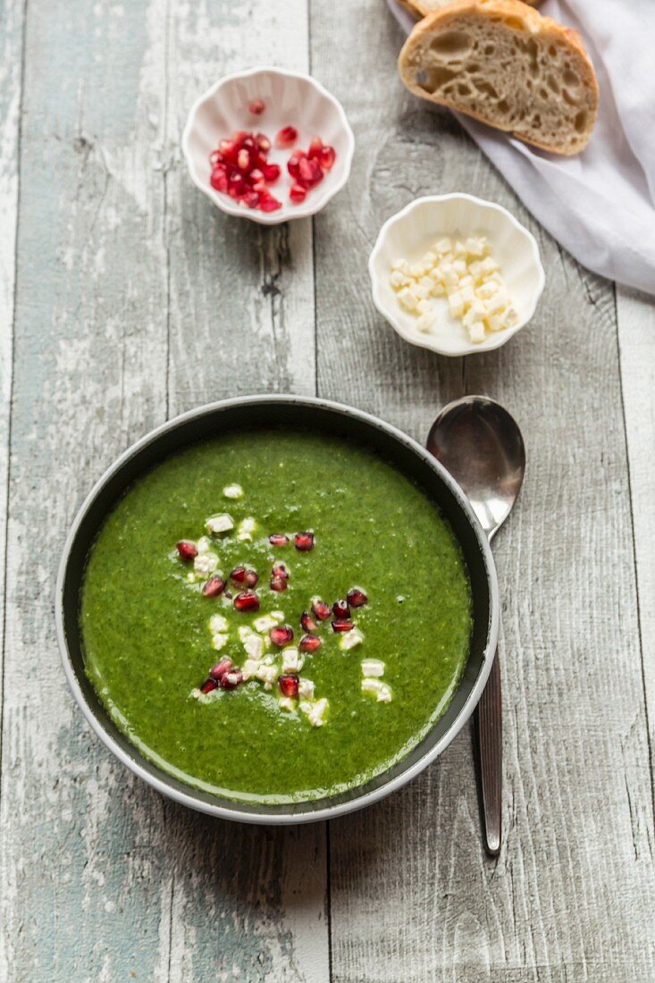 Green cabbage soup with pomegranate seeds and feta cubes