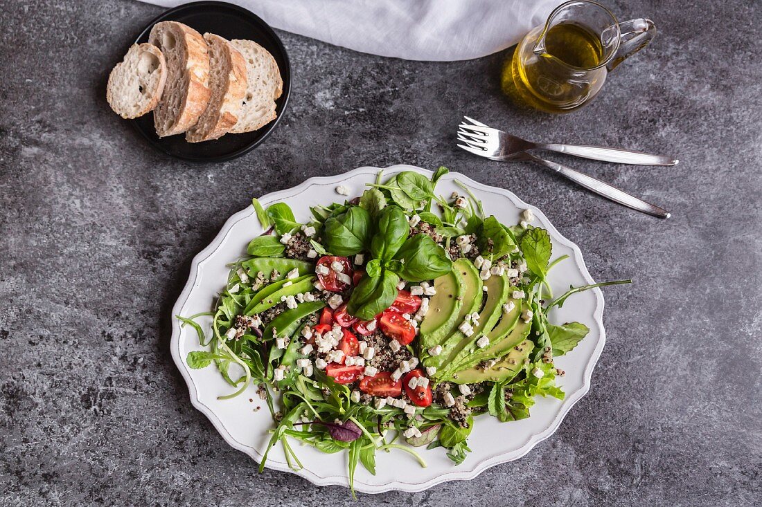 Quinoa salad with rocket, avocado, feta cubes, sugar snaps and tomatoes