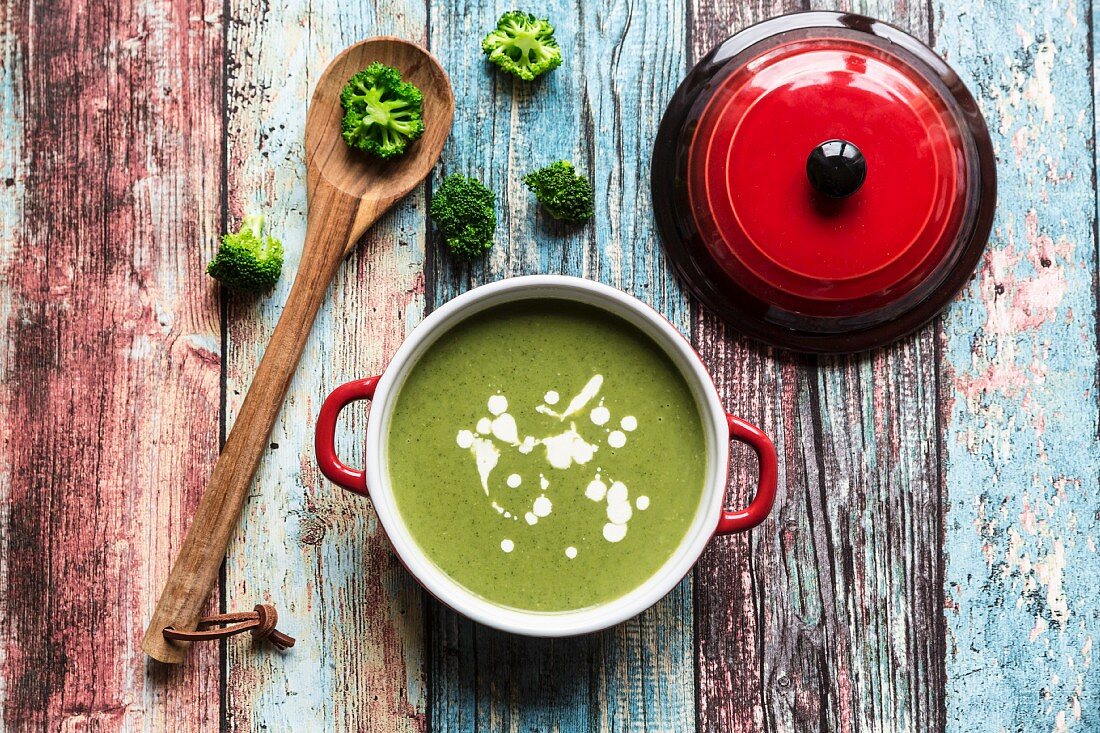 Broccoli soup, broccoli florets and a cooking spoon