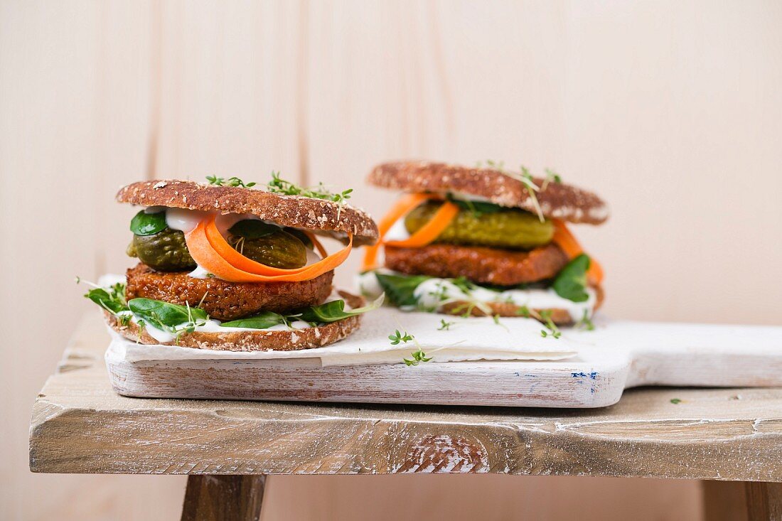 Vegan burger with tofu patty, gherkins, lamb's lettuce, carrot and cress