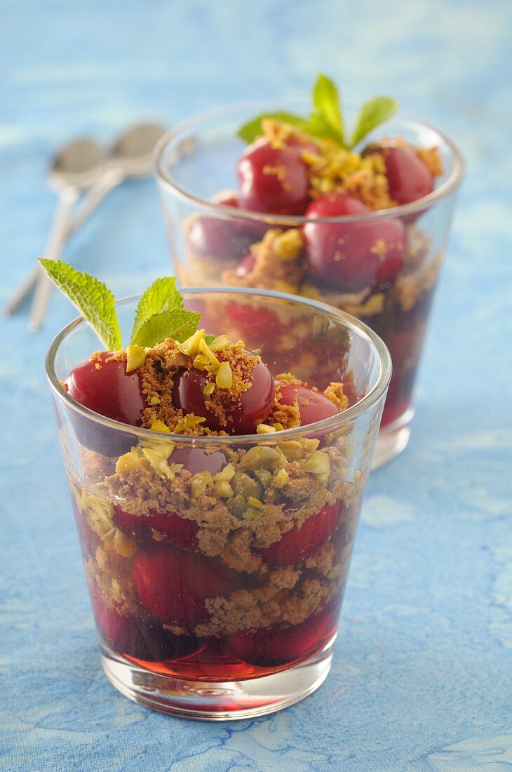 Cherry desserts in glasses with almond crumbs and pistachios