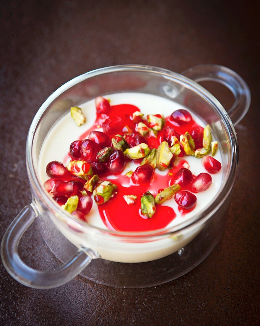 Cardamom and lemon dessert with pistachios, pomegranate seeds and rose syrup