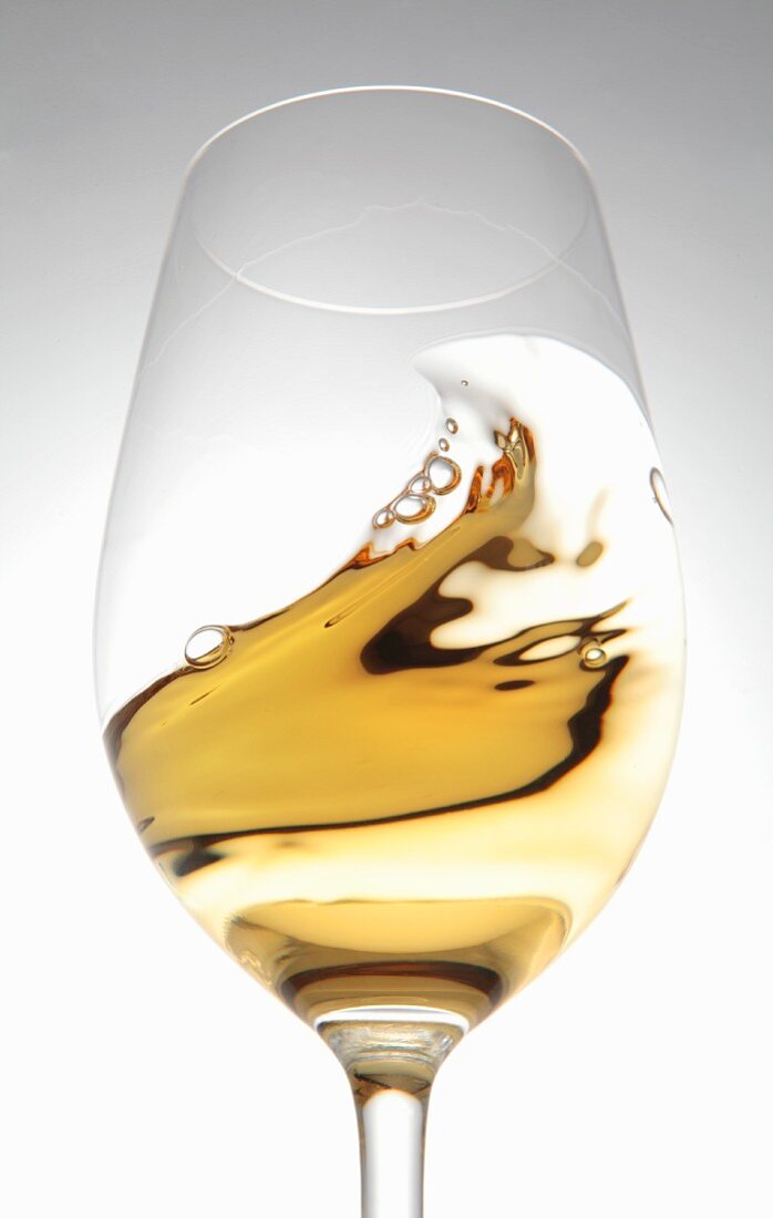 White wine in a glass with a wave