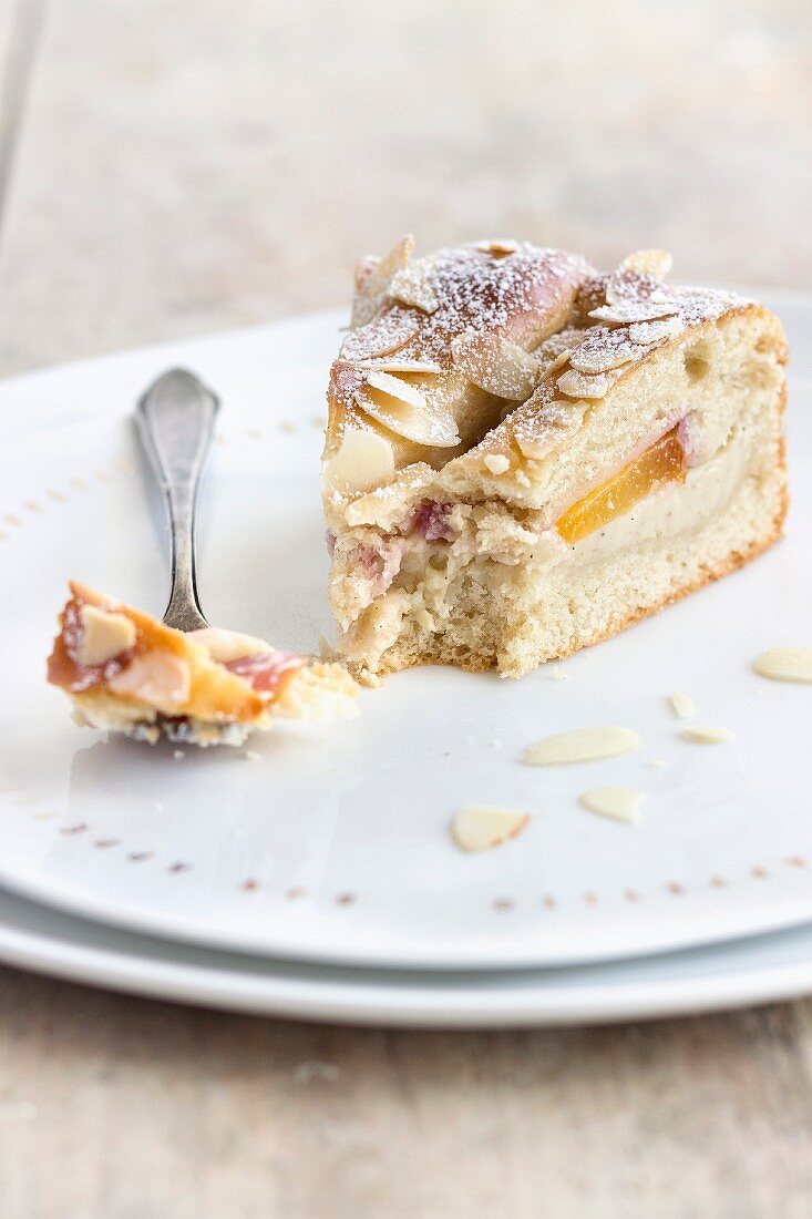 A piece of nectarine cake made from quark oil dough and filled with vanilla pudding