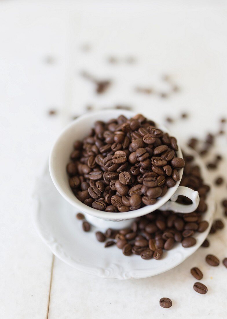 Coffee beans in a coffee cup and on a saucer