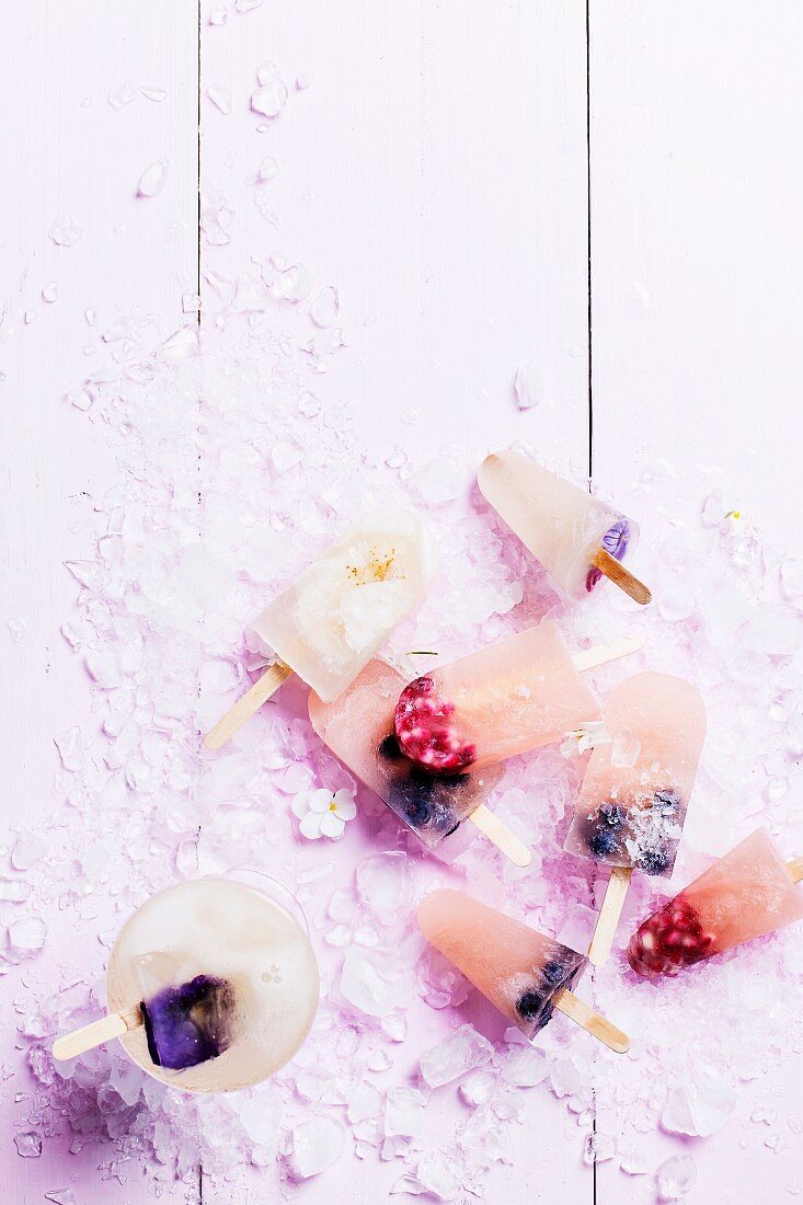 Ice lollies with berries, edible flowers and pomegranate seeds