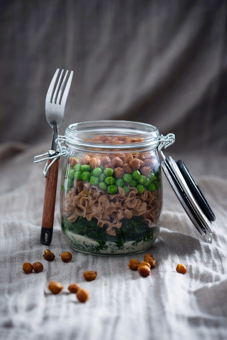 Spelt pasta, peas, broccoli, roasted chickpeas and dill sauce in a glass jar