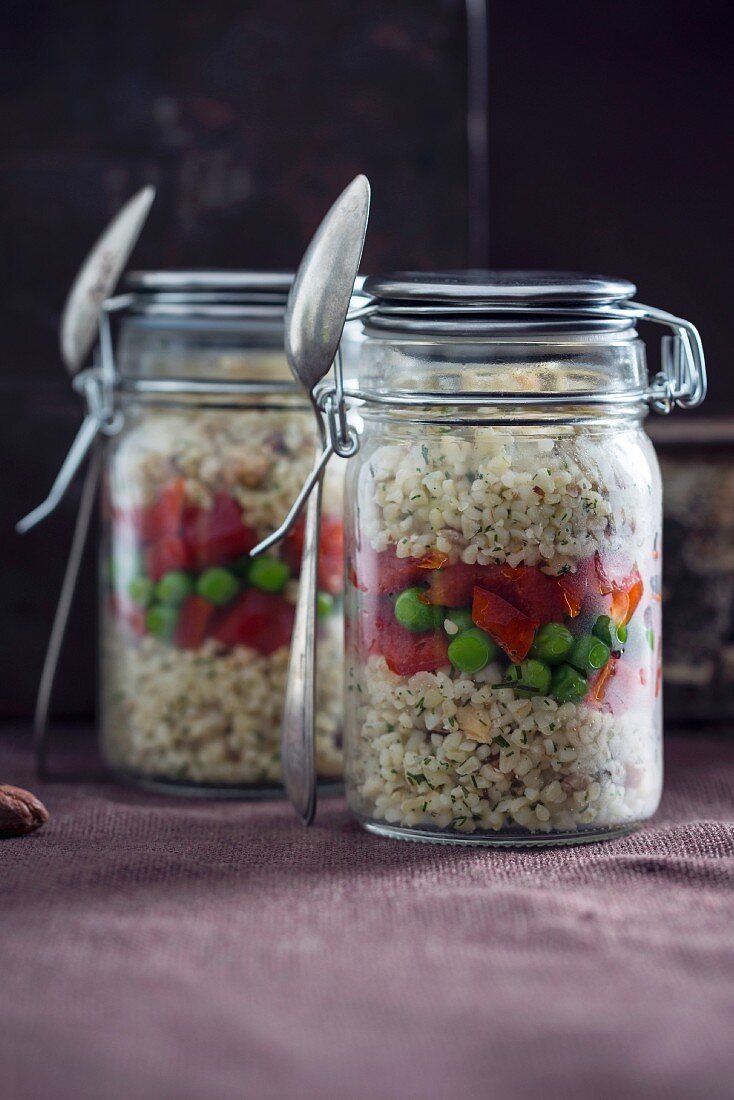 Bulgur wheat salad with hazelnuts, peppers and peas in glass jars