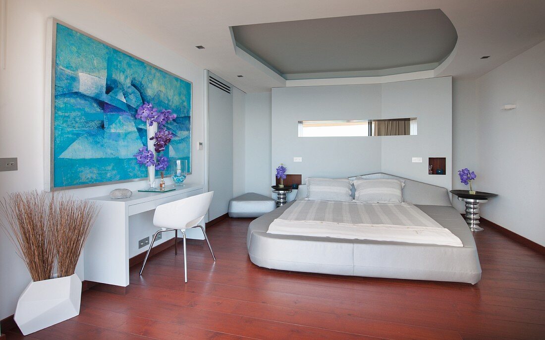 Upholstered bed and abstract art in futuristic bedroom