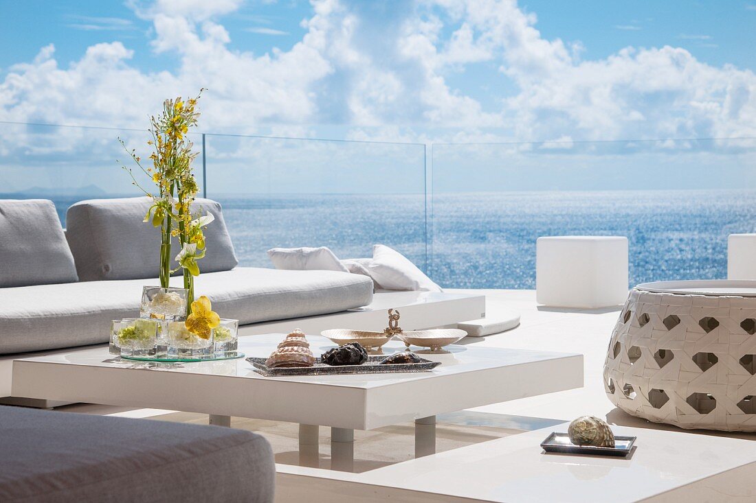 Luxurious terrace with view of sea through glass balustrade