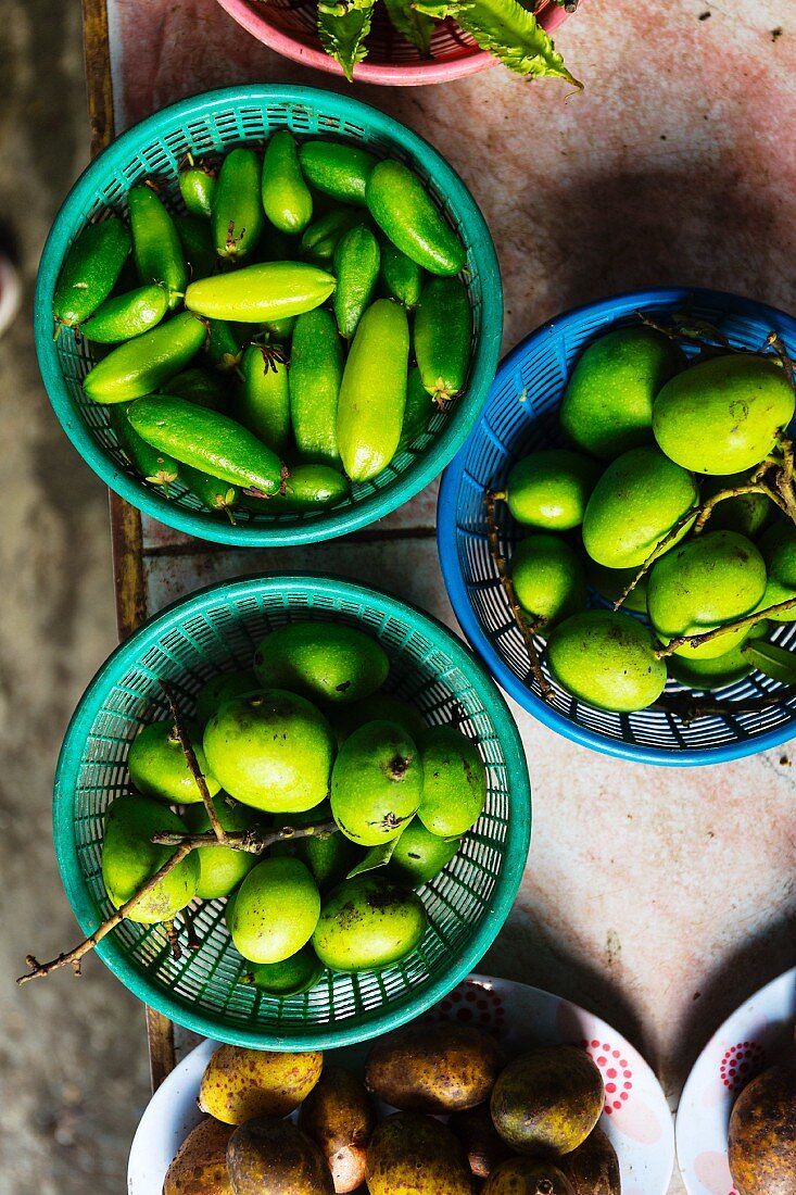 Green mangos in three bowls
