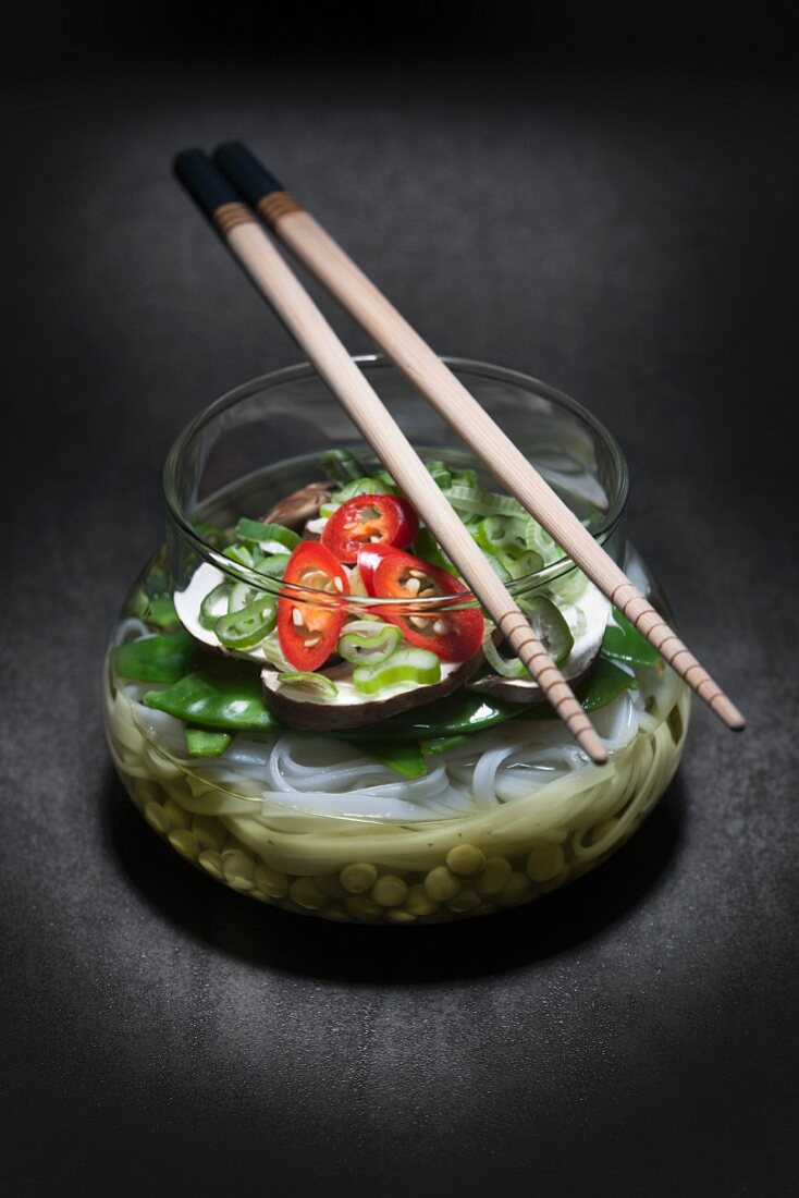 Noodle soup with vegetables in a glass bowl (Asia)