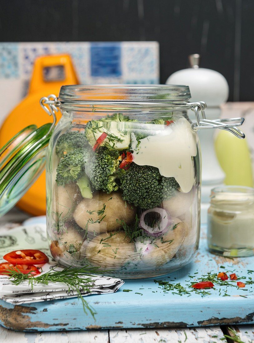 Potato salad with broccoli and vegan mayo in a glass jar