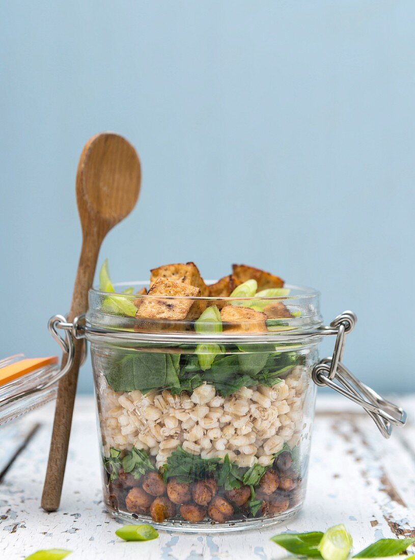 Vegan chickpea and barley salad with crispy tofu in a glass jar