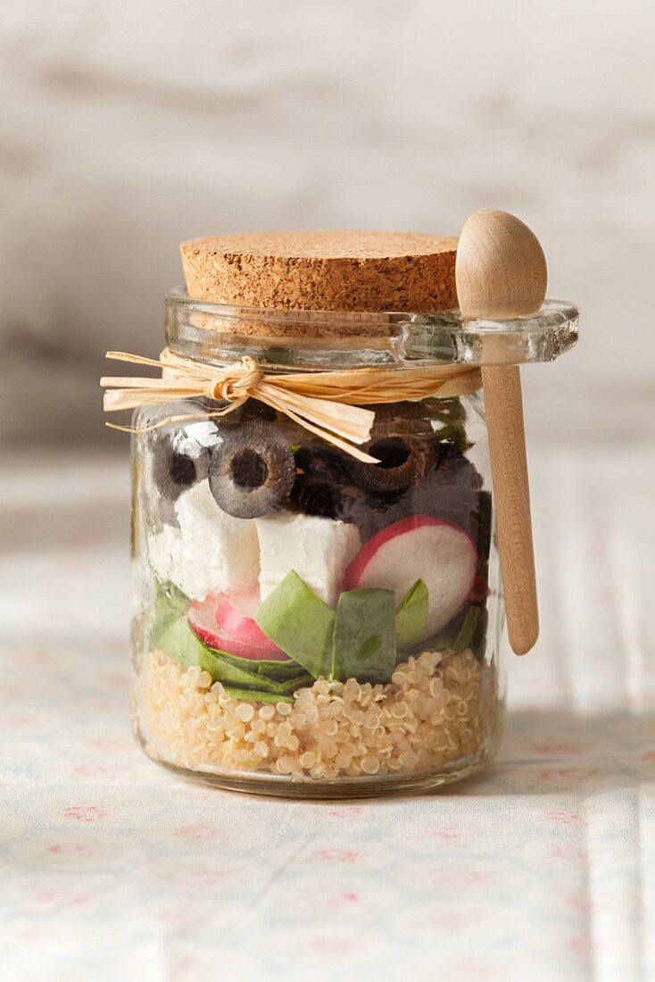 Greek style lunch jar with feta cheese and black olives in a cute jar with cork lid and wooden spoon