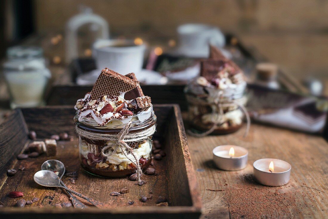 Mascarponedessert mit Schokoladenkeksen, Haselnüssen, Kakaopulver und Schlagsahne im Glas