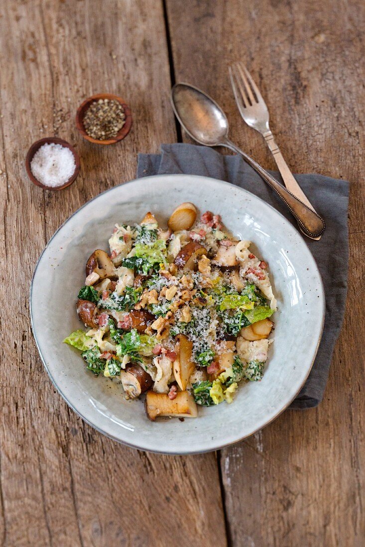 Bacon shreds with savoy cabbage and mushrooms, sprinkled with parmesan