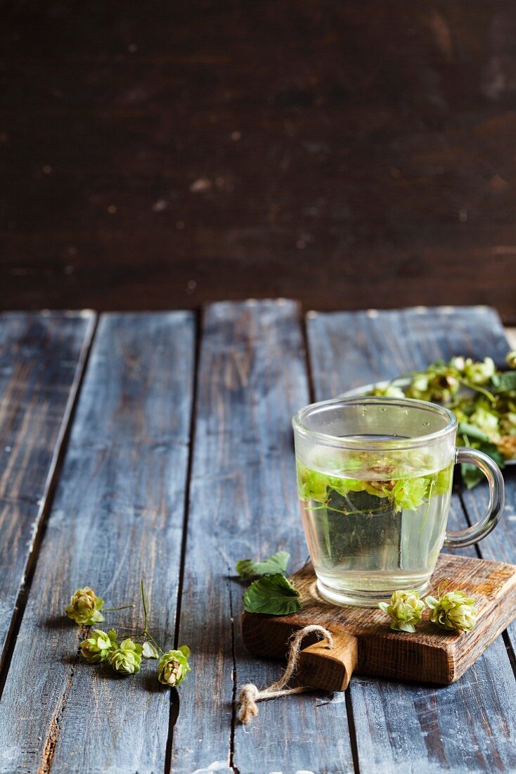 Hops tea in a glass cup on a chopping board