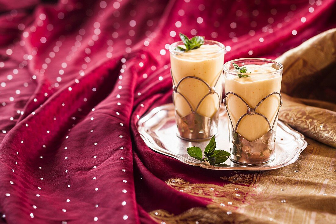Mango lassi in two glasses on a tray (India)