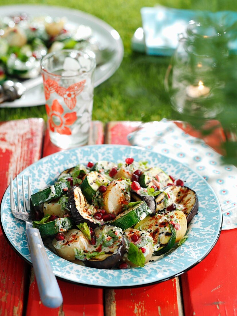 Potato salad with grilled aubergines, zucchini, pomegranate seeds and mint