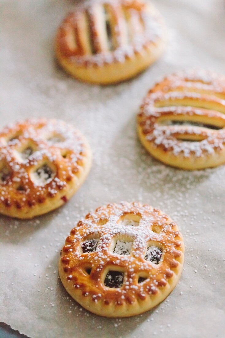 Cookies with jam and powdered sugar on parchment