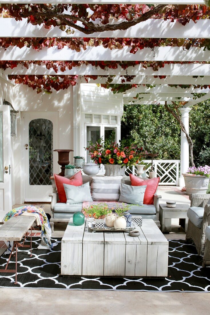 Herbstlicher Sitzplatz unter der Pergola mit Wein