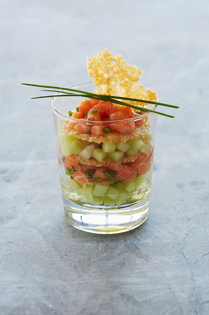 Salmon tartare served with cucumber cubes in a glass