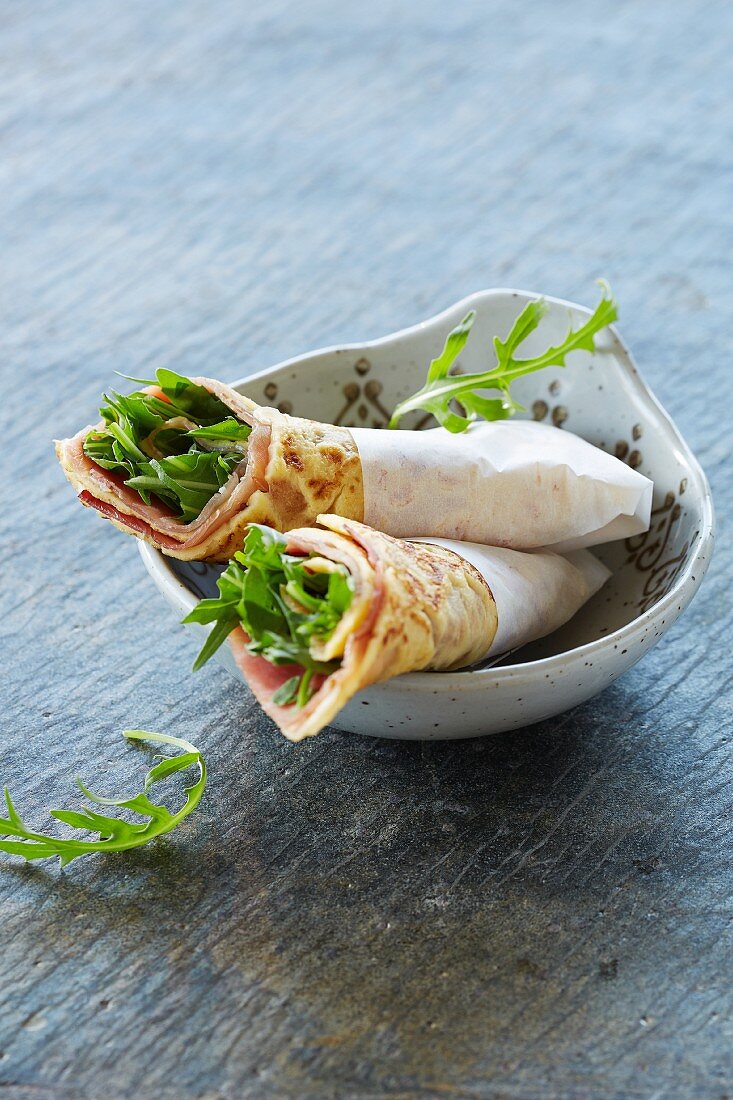 Crepe rolls with parma ham and rocket
