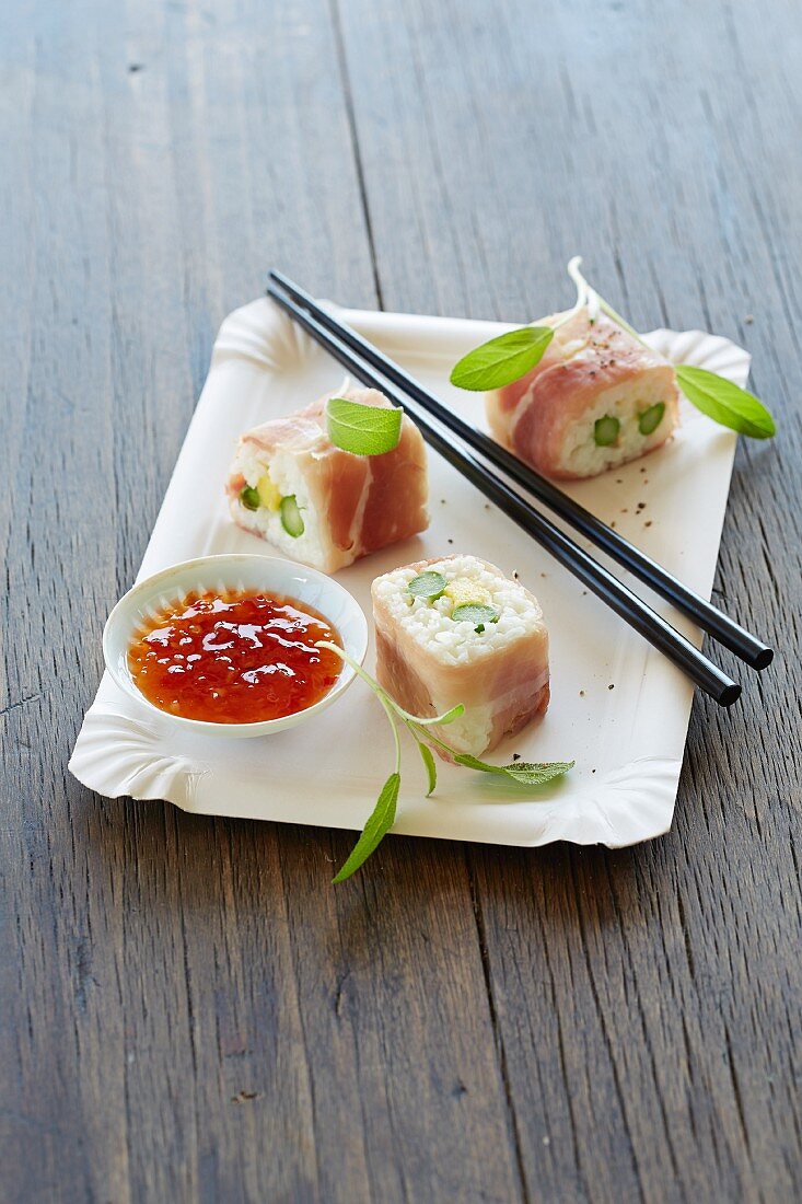 Sushi with serano ham, green asparagus and sweet and sour sauce