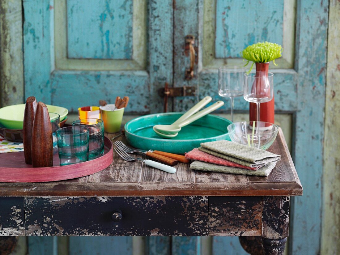 A buffet table laid with dishes, napkins, glasses, trays, salt and pepper