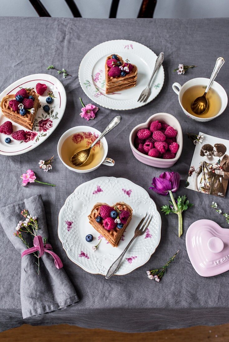 A table set for Valentine's Day with waffles, berries and tea