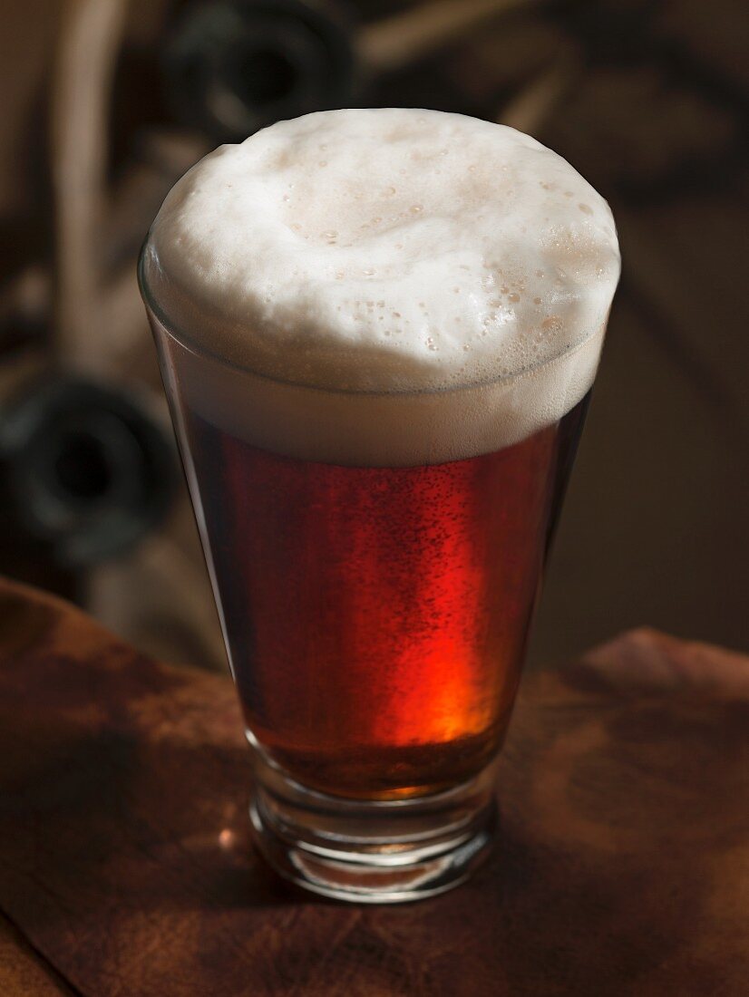 A glass of dark beer with foam