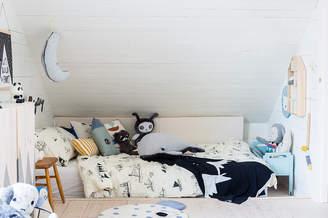 Soft toys on child's bed in child's attic bedroom