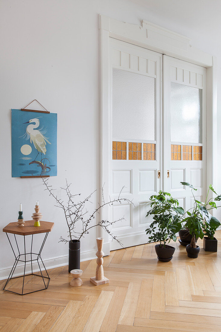 Houseplants on floor in front of closed double doors in period apartment