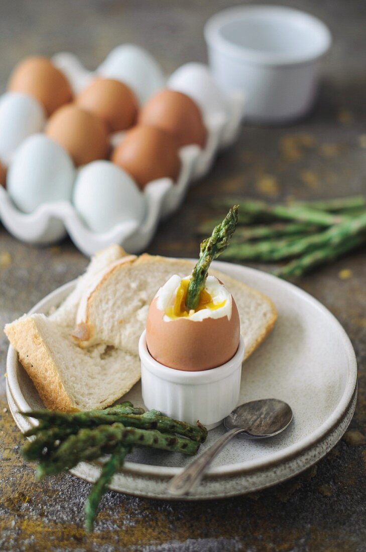 A soft-boiled egg with asparagus and toast soldiers