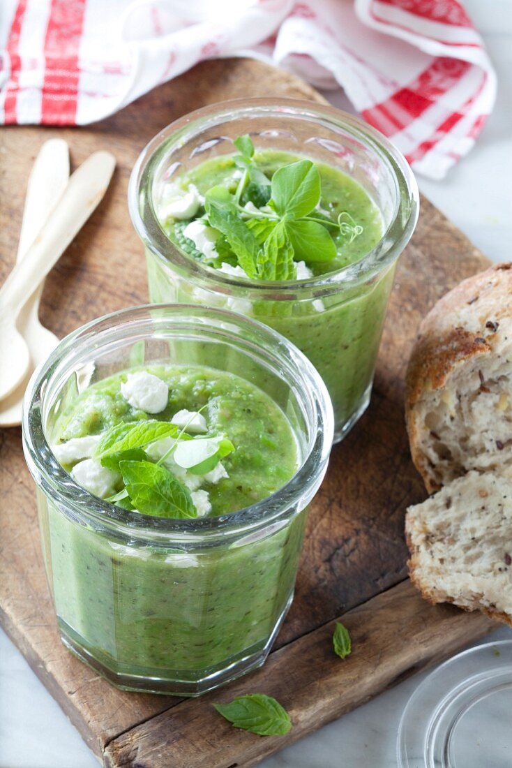 Cold pea and zucchini soup with mint and feta in glasses