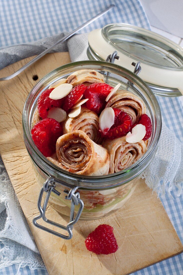 Pancake rolls with fresh fruit in a glass jar