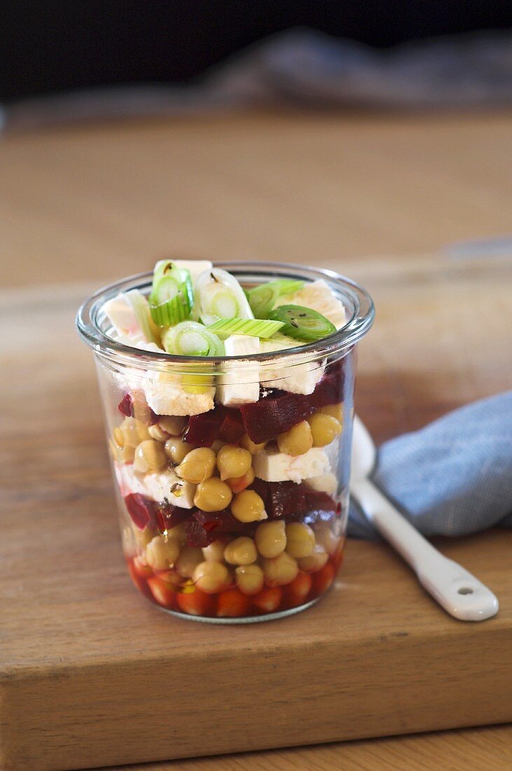 Chickpea salad with beetroot, feta and spring onions in a glass