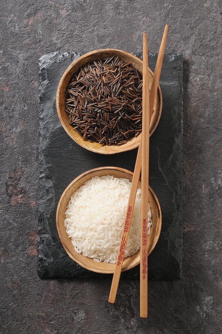 White and black rice in small bowls (top view)