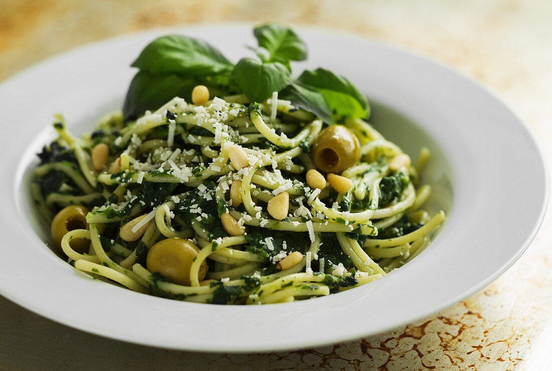Spaghetti with spinach pesto and green olives