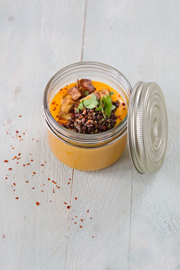 Sweet potato soup with black lentils and fried tofu in a glass