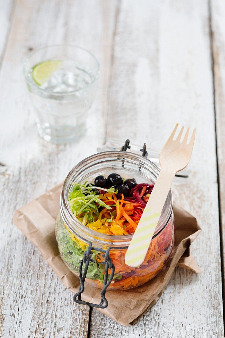 Regenbogensalat im offenen Glas mit Roter Bete, Karotten, gelber Paprika, grünem Salat und Blaubeeren