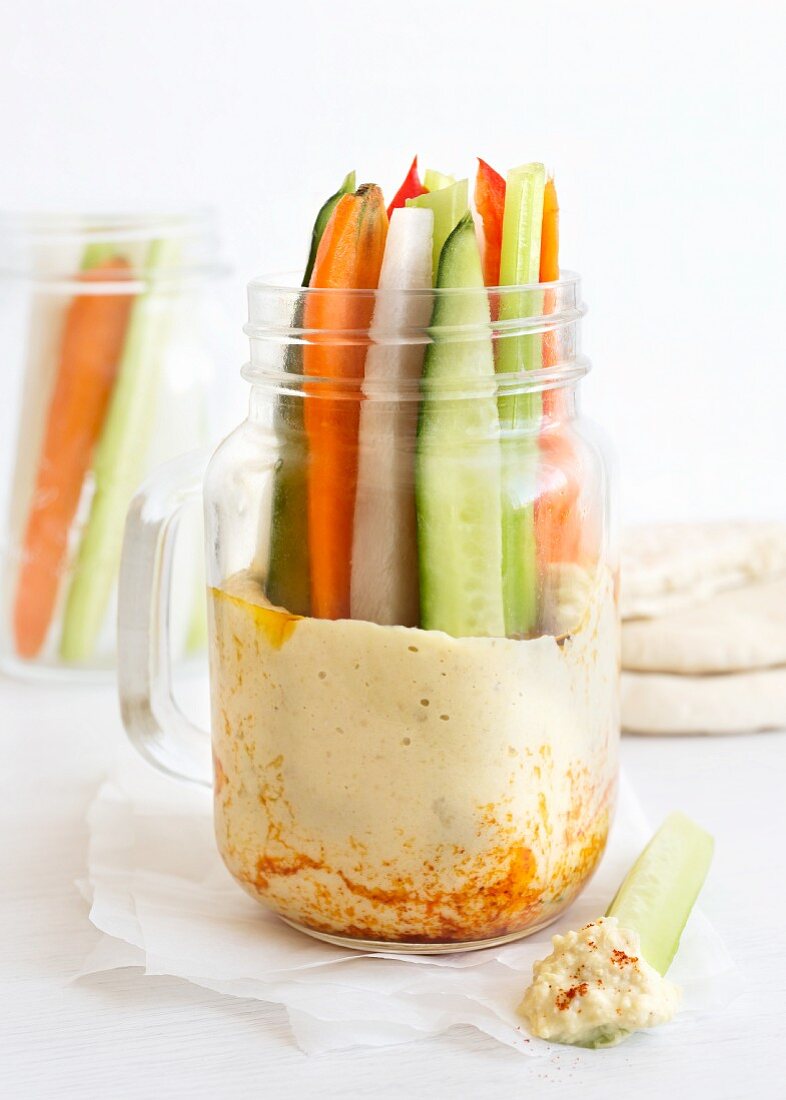 Vegetable sticks in a glass jar with houmous