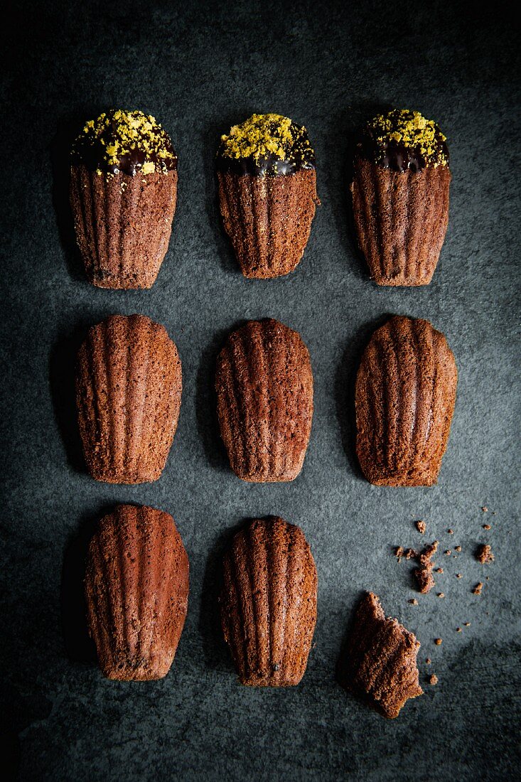 Chocolate madeleines with a chocolate glaze and pistachio crumbs (top view)
