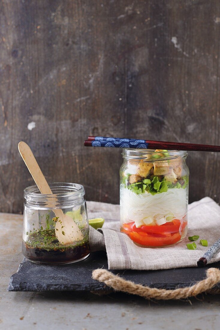 A glass noodle salad with peppers and tofu in a glass jar