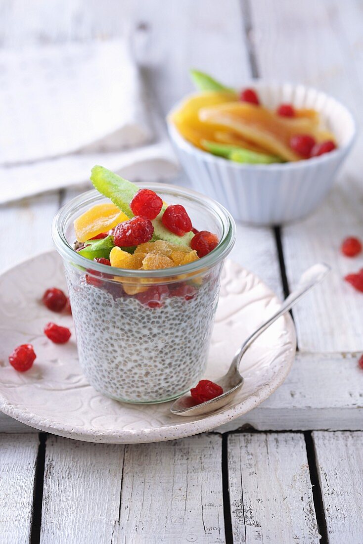 Coconut chia pudding with candied fruits in a glass