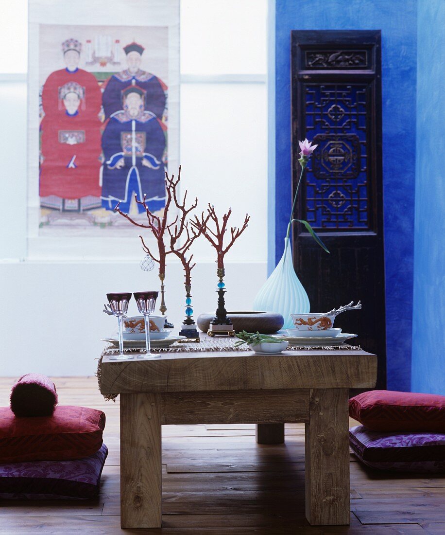 Rustic wooden table set in Oriental style and floor cushions