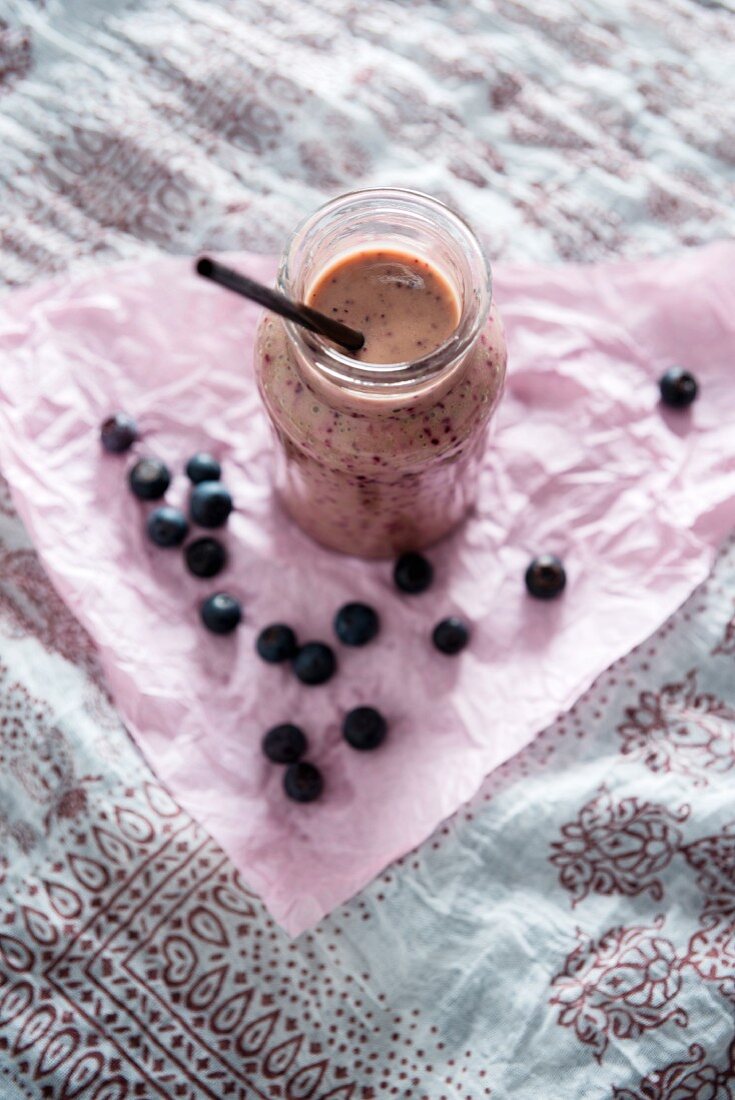 A vegan blueberry and yoghurt smoothie in a glass jar